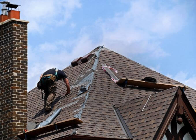 Roofers installing metal shingles