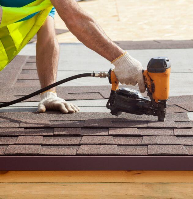 Shingles being installed on an unfinished roof